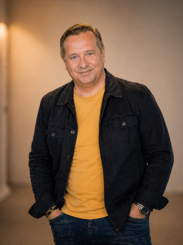 Niklas Jeppsson i gul tröja och mörk jeansjacka.